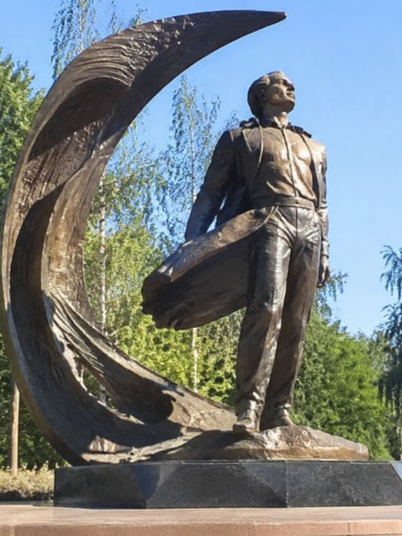 Бронзовый монумент лётчику на фоне месяца