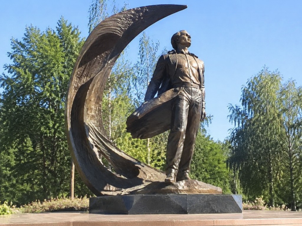 Бронзовый монумент лётчику на фоне месяца